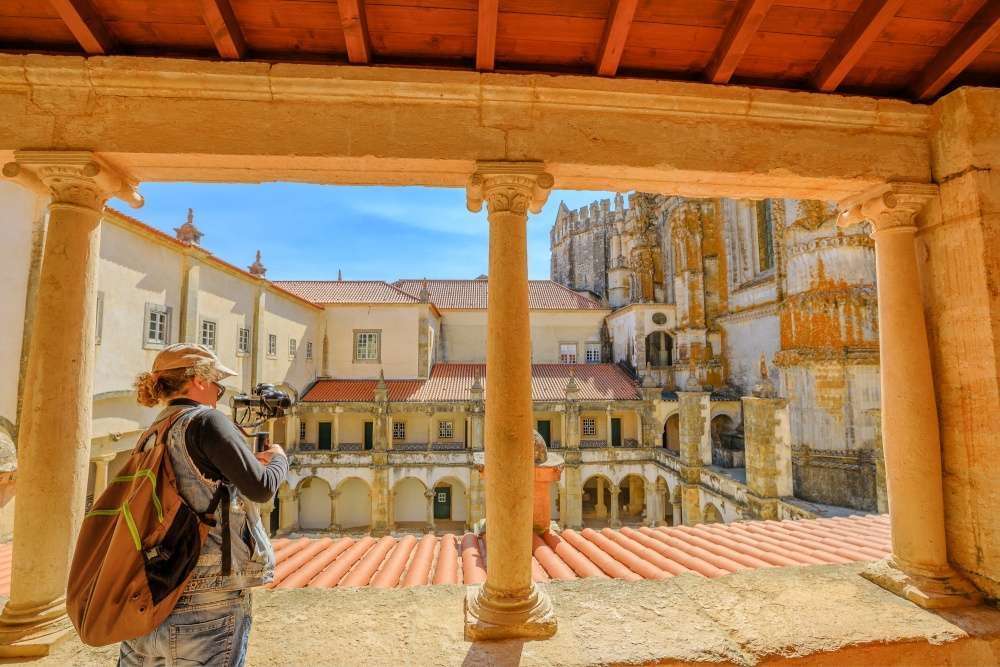 Viajante tirando fotos no Mosteiro de Tomar, Portugal