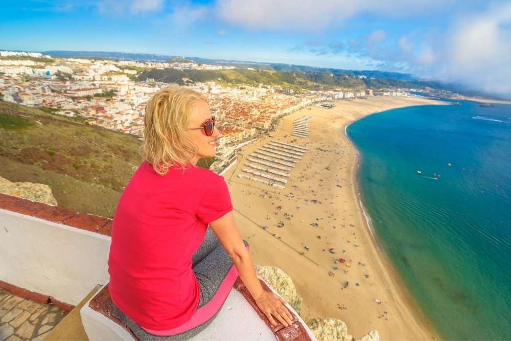 Viajero en el mirador de Sítio mirando la playa de Nazaré, Portugal