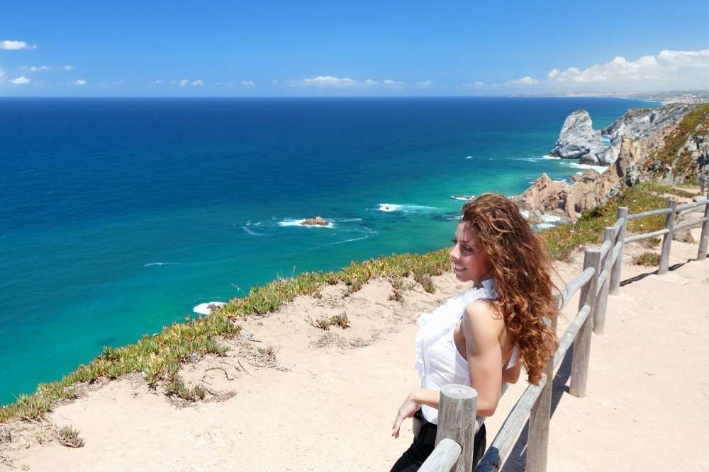 Chica mirando el Océano Atlántico en el Cabo de la Roca (Cabo da Roca), Portugal